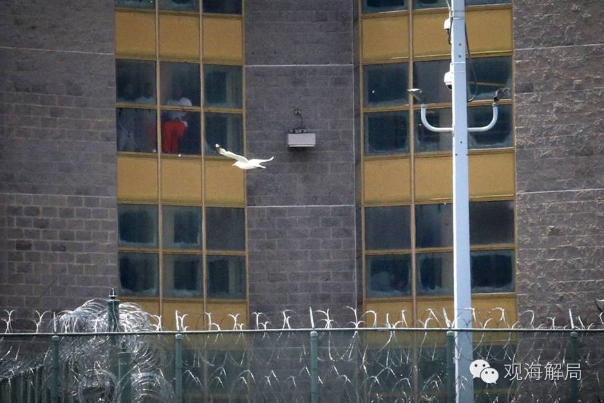 （图为哈德逊县惩教中心，可见围栏被铁丝层层环绕，从窗户中可以隐约看到一些犯人的身影。图片素材来源于网络）