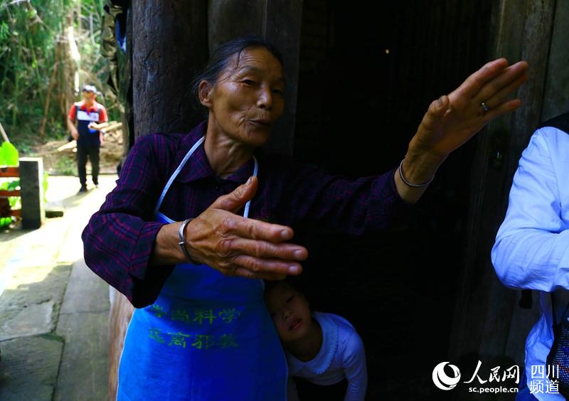 67岁老人骆朝群一家人就居住在三十军指挥部旧址，她说老人们总是讲起红军的故事。（朱虹 摄）