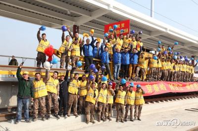 　工人们热烈庆祝铺轨完成。