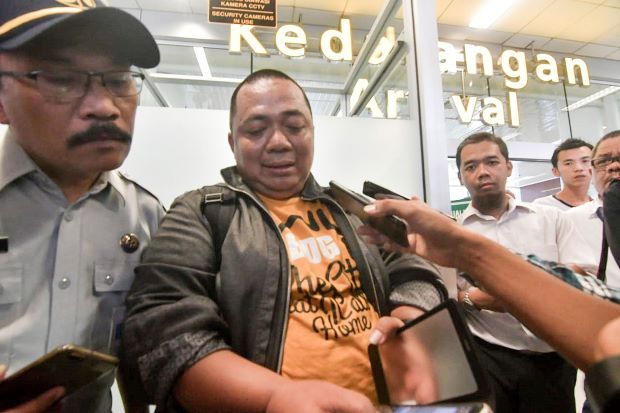 Sony Setiawan (C) speaks to journalists at Pangkal Pinang airport in Bangka Belitung province on October 29, 2018, following his arrival on another airline after missing his pre-planned flight on Lion Air flight JT 610 which crashed off the coast north of Jakarta. - Setiawan was due to board the ill-fated Boeing-737 MAX but was held up on his commute to Soekarno-Hatta airport by Jakarta’s notorious traffic congestion. The brand new Indonesian Lion Air plane carrying 189 passengers and crew crashed into the sea on October 29, officials said, moments after it had asked to be allowed to return to Jakarta. (Photo by RONI BAYU / AFP).