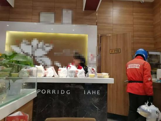 某餐厅柜台上摆满了等待配送的外卖