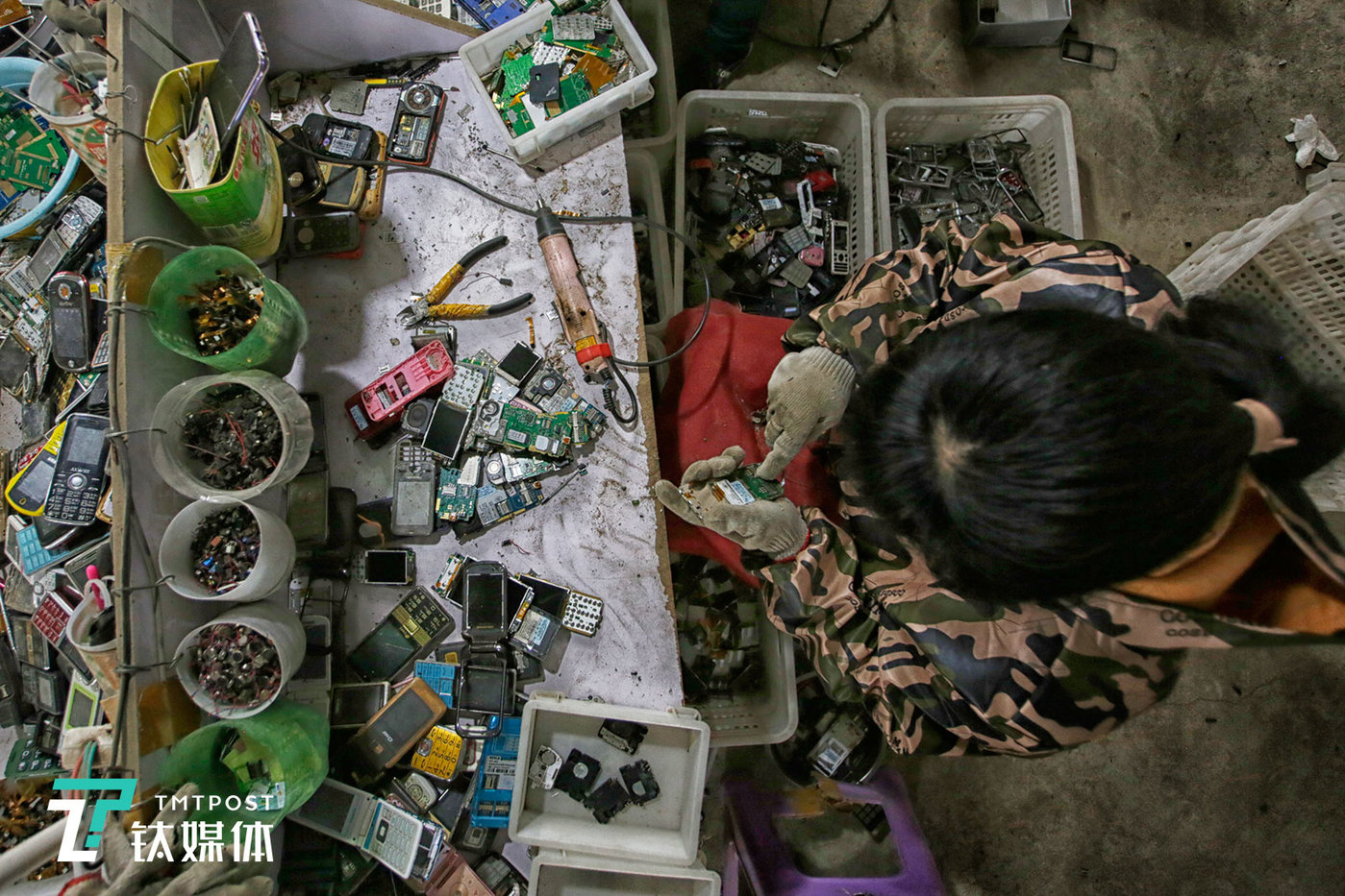 一名女工在拆解一台老年机。