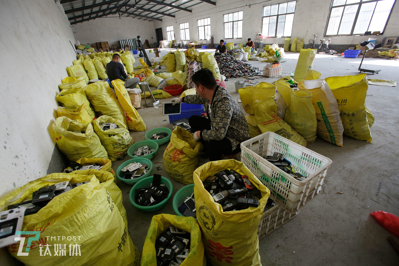 王勇的仓库里，几个合伙人在按照型号和品牌分拣废旧手机。王是当地较大的一户回收商，在手机回收行业从业多年，“山东是中国废旧手机回收比较集中的地方，梁山又是做得早，从业者比较多的地方。”