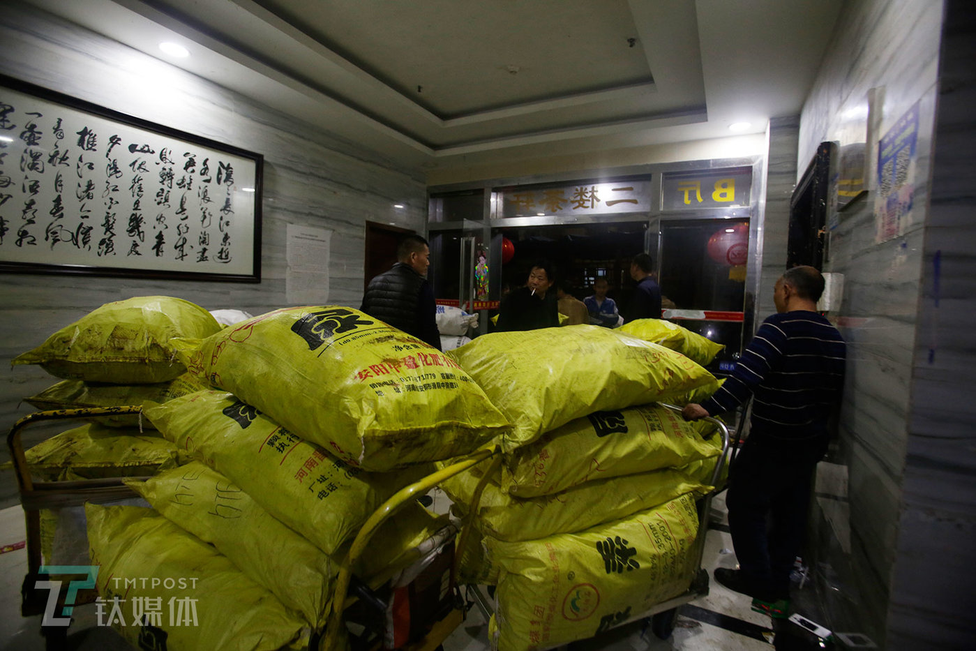 2019年2月25日凌晨2点，深圳华强北附近一处废旧手机市场，搬运工和货主等待上楼的电梯，黄色的编织袋里装着刚刚送到的废旧手机。这个市场24小时运转，全国各地的货源源不断地来到这里。