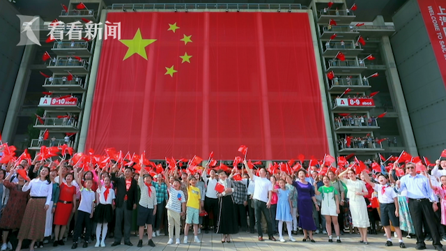 巨幅国旗徐徐展开，将现场气氛推向高潮