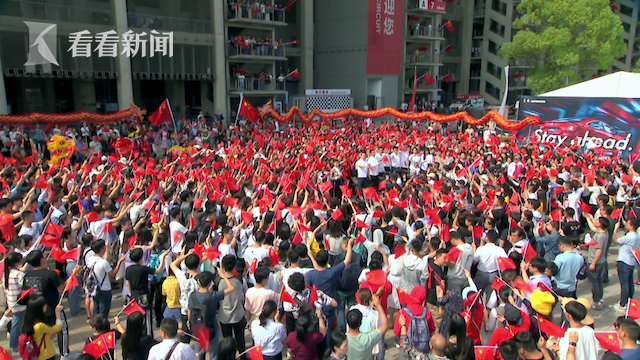 快闪活动现场，现场观众手举国旗高唱《我和我的祖国》