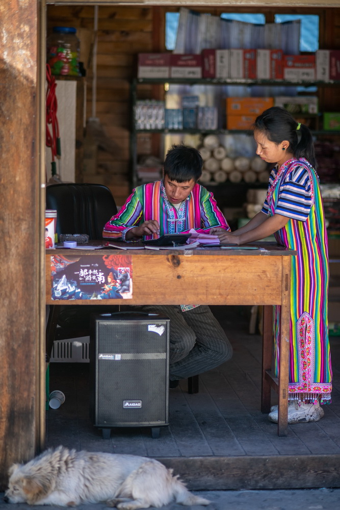 在云南省贡山独龙族怒族自治县独龙江乡迪政当村,独龙族青年李斌(左)和妻子李元梅在自家开的小卖部统计当天收入(10月29日摄)。新华社记者 胡超 摄