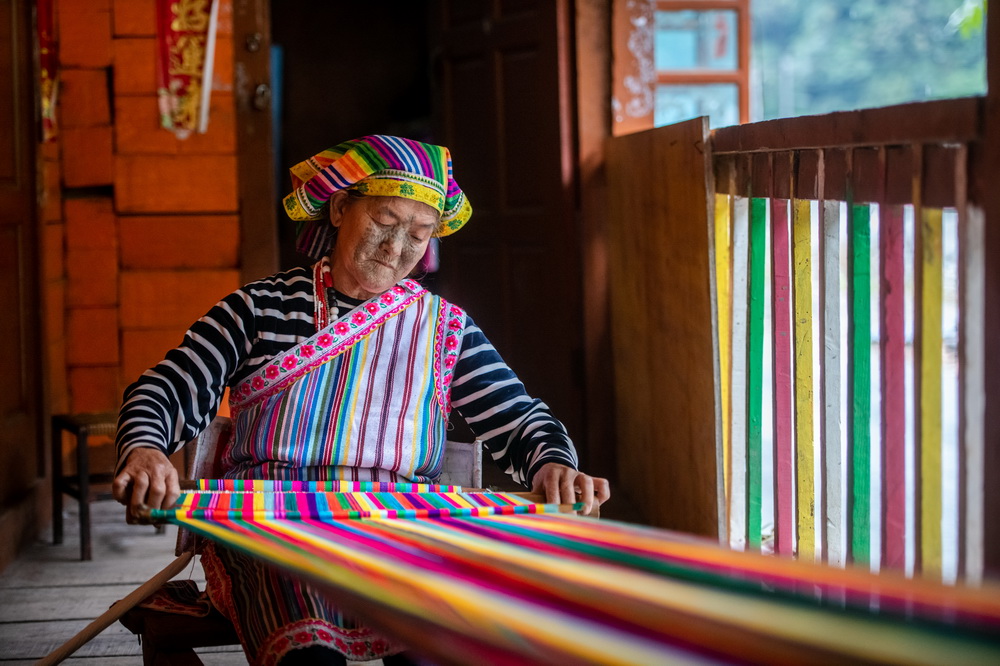 在云南省贡山独龙族怒族自治县独龙江乡,独龙族“文面女”李文仕在织独龙毯(10月27日摄)。新华社记者 胡超 摄