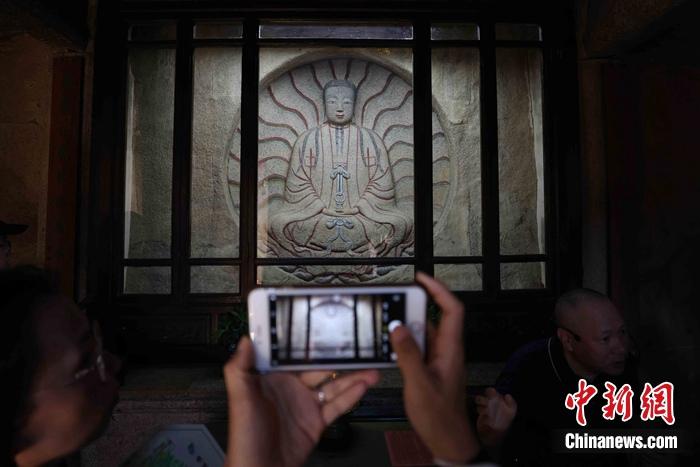 7月9日，泉州草庵摩尼光佛造像吸引参观者拍摄。蒋启明 摄