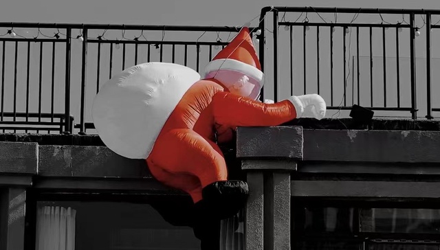 平安夜，圣诞老人忙着在商店门口爬墙