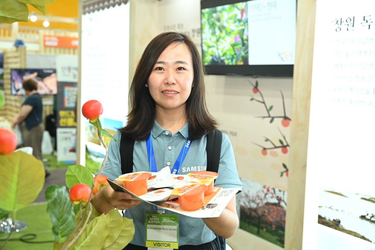 “村带头人访韩”活动期间，杨维娜参观农博会柿子深加工产品