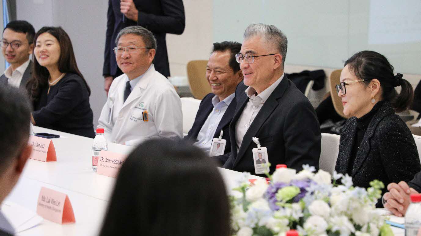 A group of men sitting at a tableAI-generated content may be incorrect.