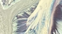 受台风“白海豚”影响，钱塘江江滩现“大地流沙画”。滩涂之上，泥沙舒展如万千羽毛